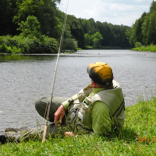 Fly fisherman lounging on bank of the Grand River
