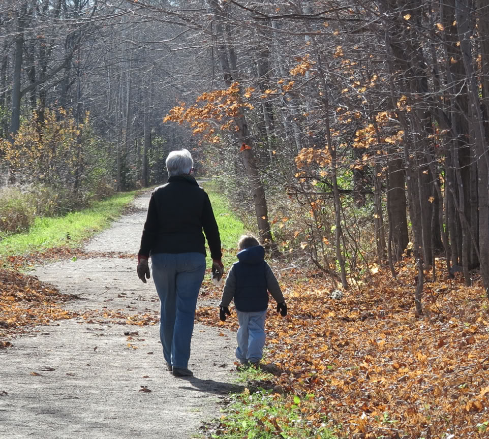 Autumn scene of a woman and young boy walking along the Elora Cataract Trailway