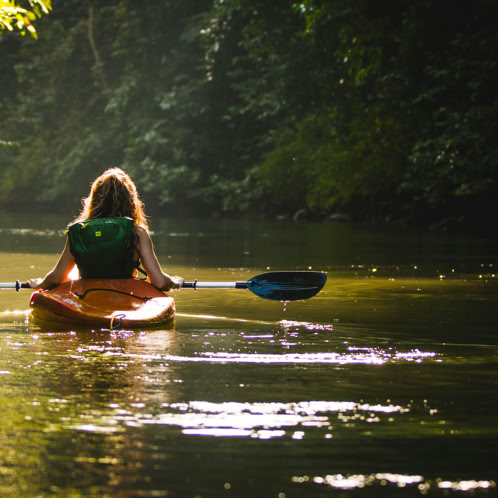 Back of woman paddling a kayak