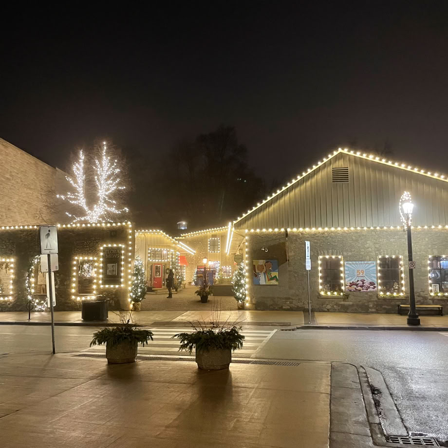 A scenic view of the Elora Mews decorated with winter lights.