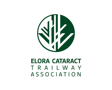 A man focuses on fixing his mountain bike tire in a forest setting, wearing a plaid shirt and bandana.